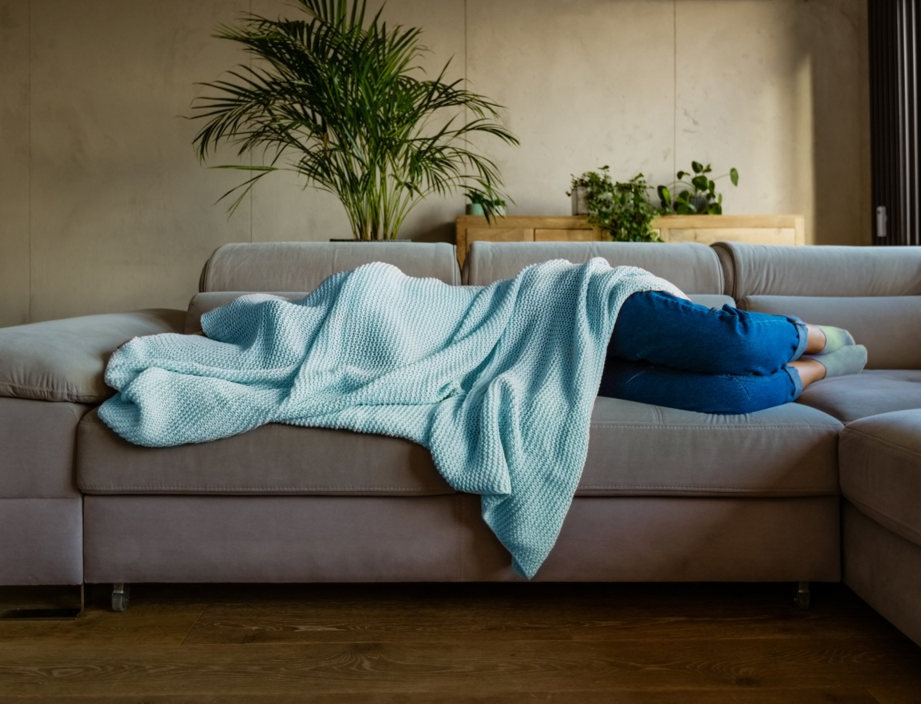 woman-laying-on-couch-under-blanket@2x.jpg